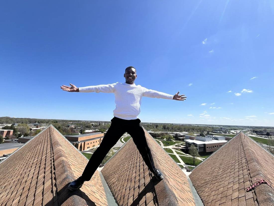 Kuda standing on a rooftop with arms wide open